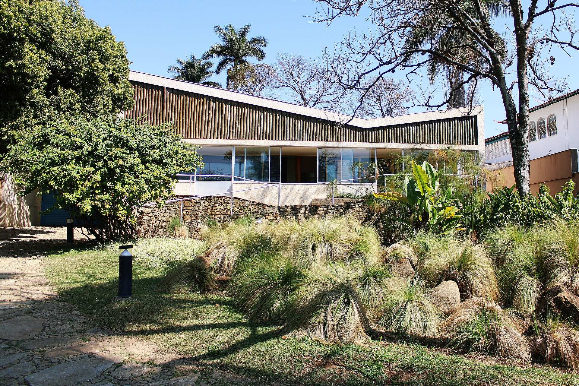 Fachada do Museu Casa Kubitschek, de telhado em formato de borboleta, com jardim em primeiro plano