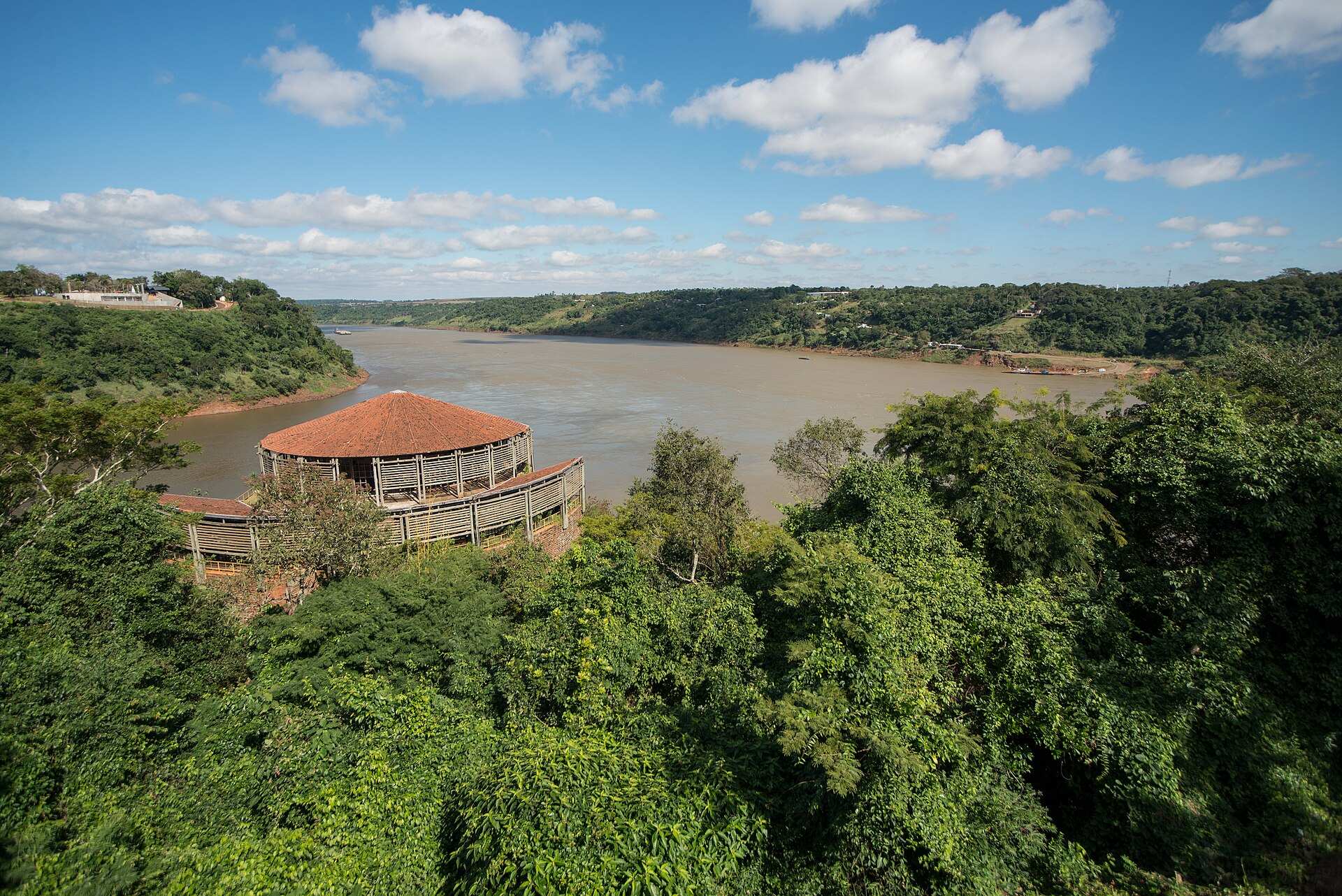 Mirante circular de telhado vermelho entre a mata, com o rio largo ao fundo, no Marco das Três Fronteiras
